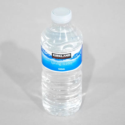 Kirkland Signature 500ml bottle of spring water with a blue label and white cap, placed on a plain background.